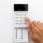 Hand is setting home security alarm system